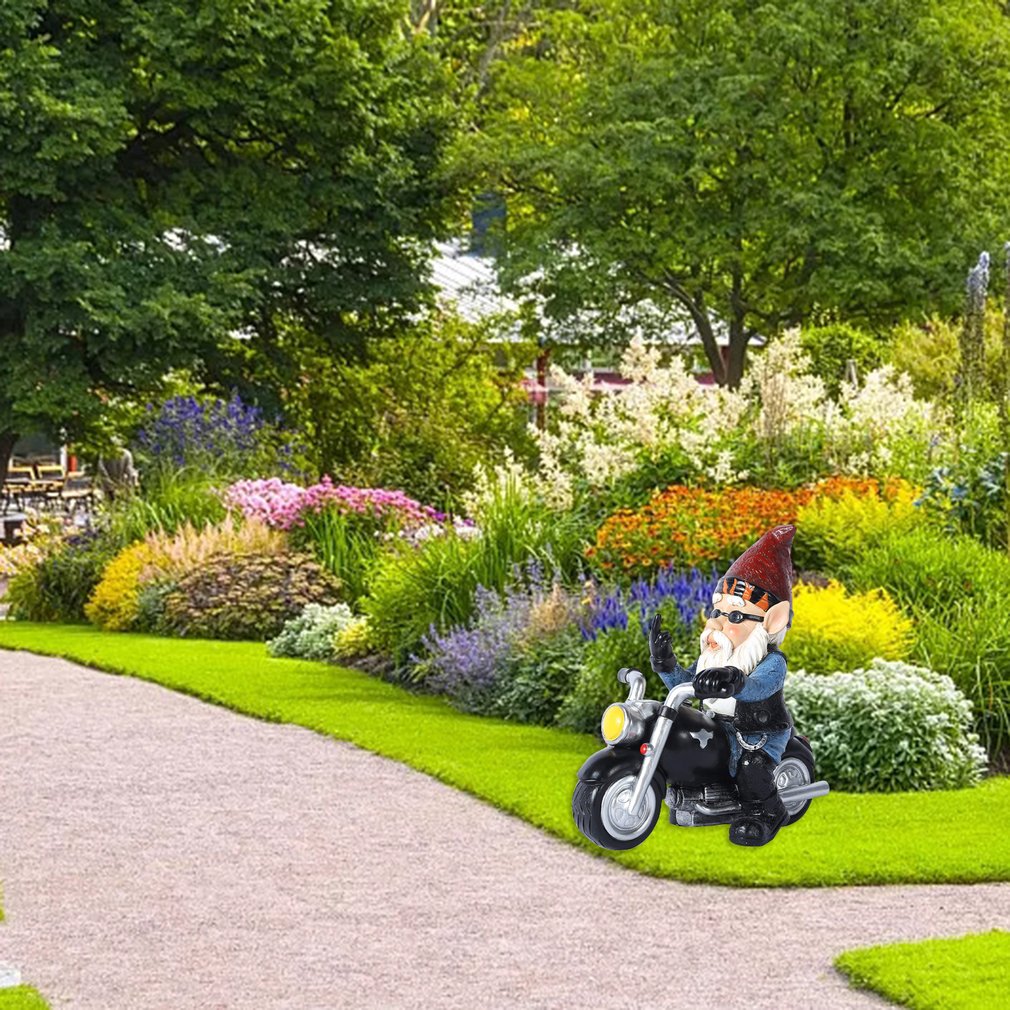 nain de jardin sur une moto dans un jardin